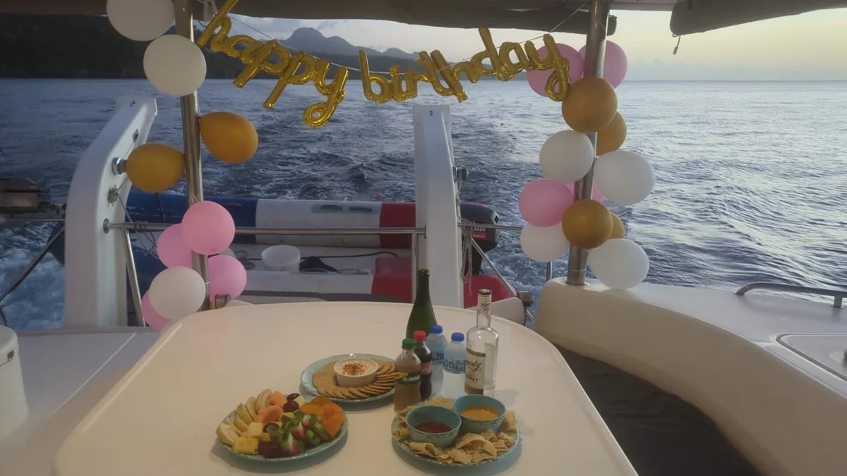 Birthday balloon display at the stern of Island Girl with the Pitons behind