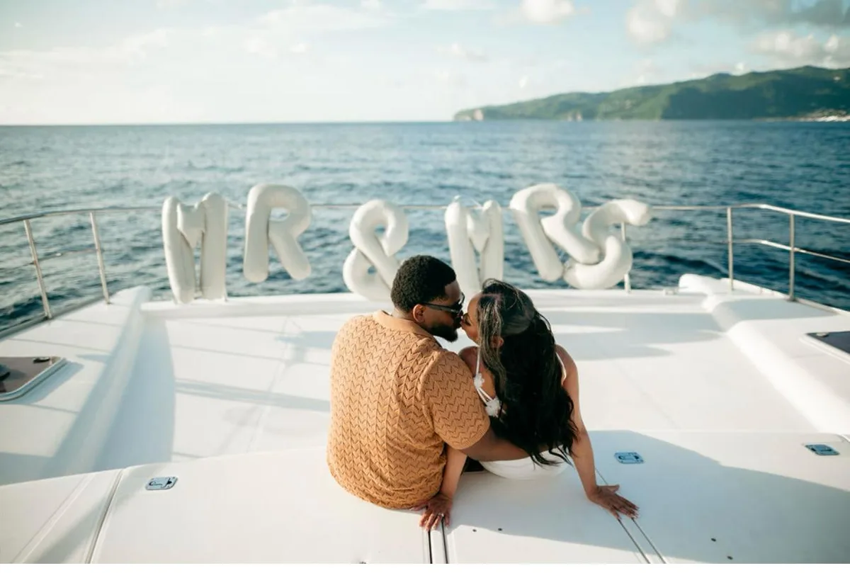 Wedding couple with Mr and Mrs balloon letters on the bow of a private catamaran in St. Lucia