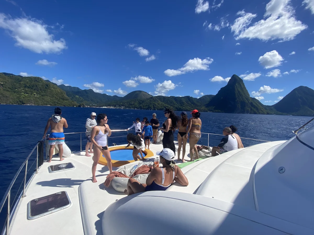 Guests relaxing on the bow of Island Girl with the Pitons of St. Lucia behind them